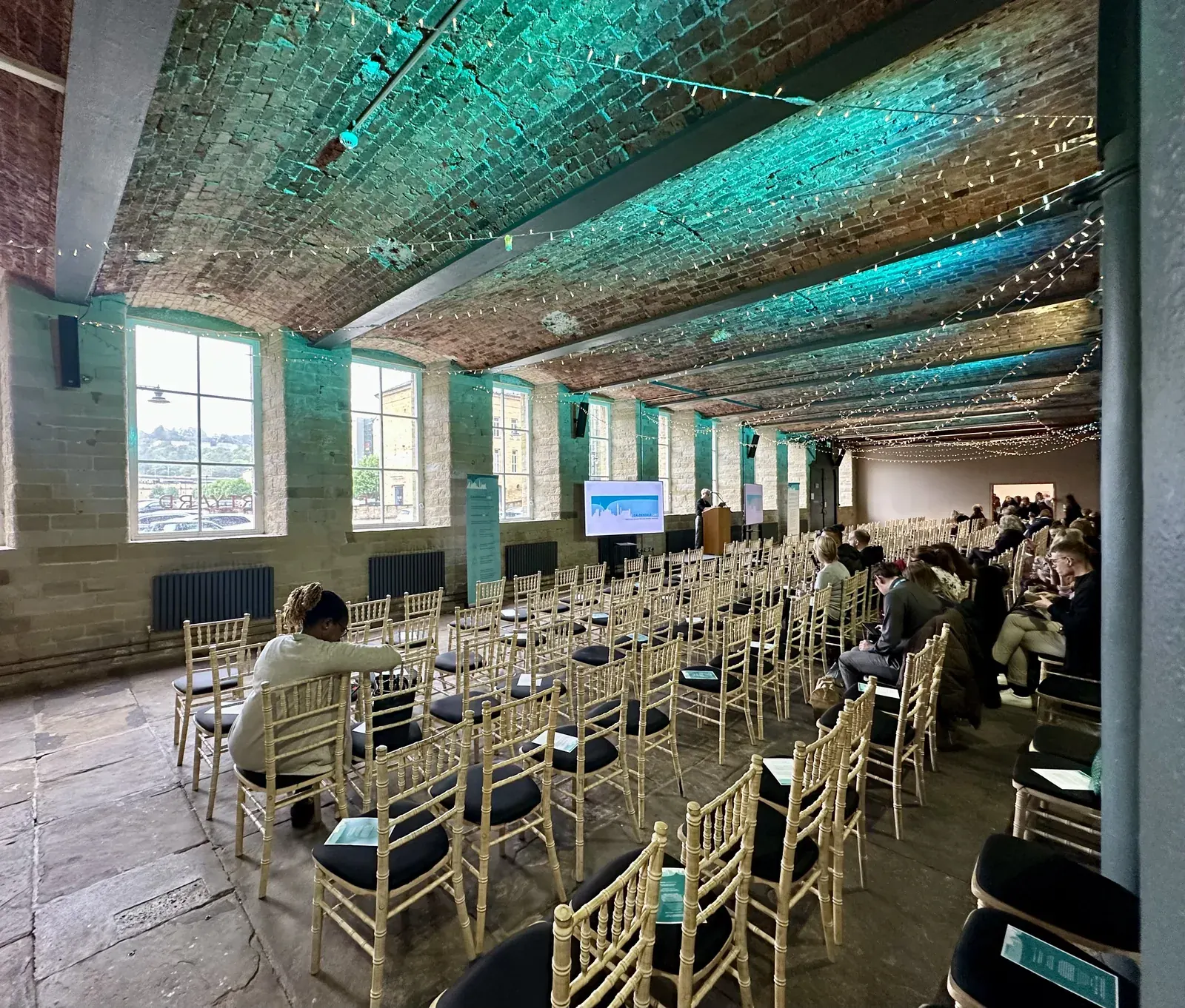 The hall at The Arches set theatre-style for a conference, with a presentation screen